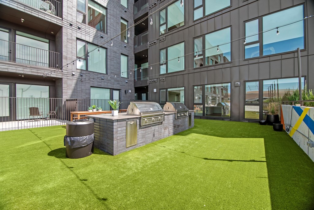 the yard has a grill and bbq area with grass