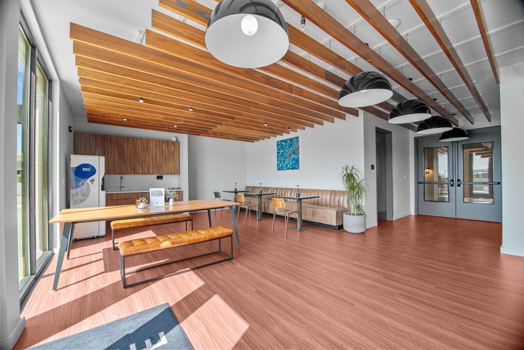 a living room with a wooden floor and a table and chairs