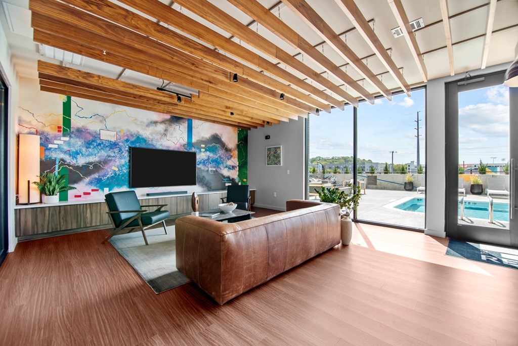 a living room with a leather couch and a large wall mural