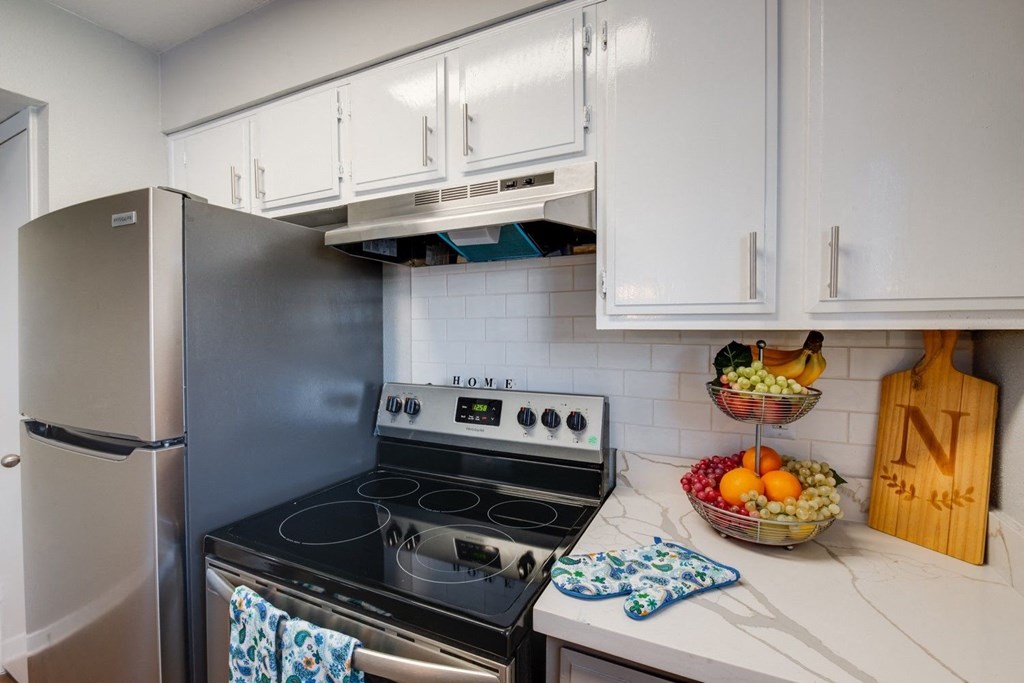 a kitchen with stainless steel appliances and white cabinets