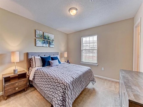 A bedroom with a large bed and a window.