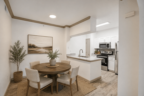A modern kitchen with a dining table and chairs.