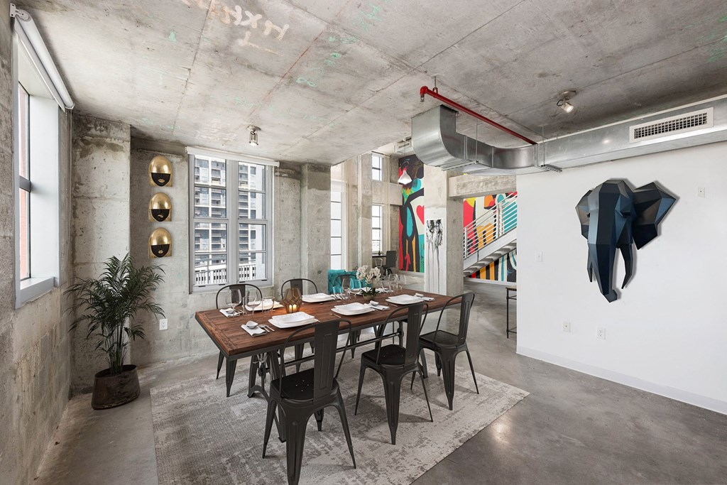 a dining room with a long wooden table and black chairs