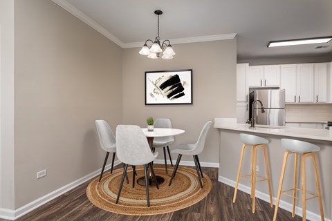 A dining area with a white table and chairs.