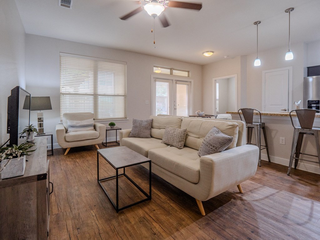 a living room with a couch and a chair in front of a dining room table