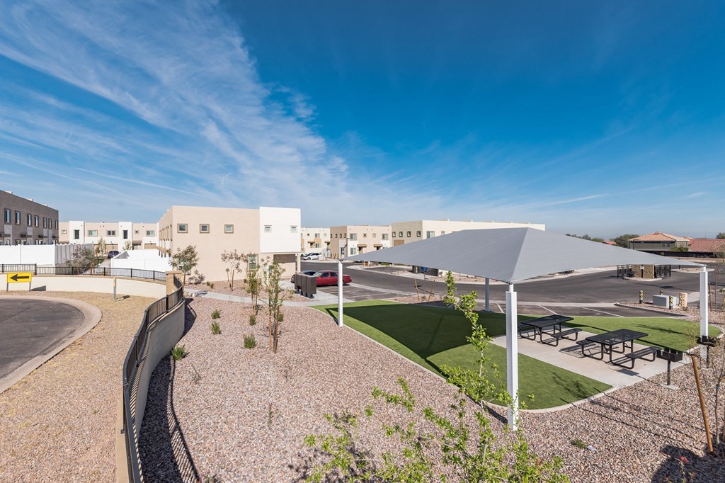 a view of the courtyard of a building with benches and umbrellas