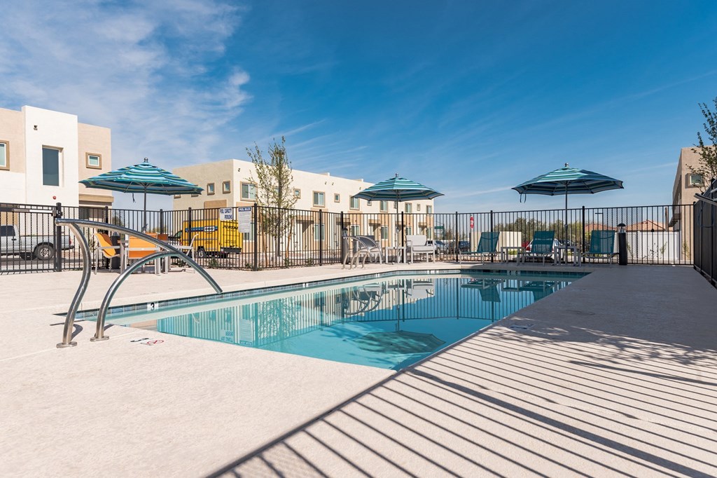 our apartments have a swimming pool with chairs and umbrellas