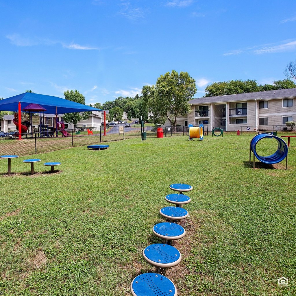 a park with agility obstacles and buildings in the background