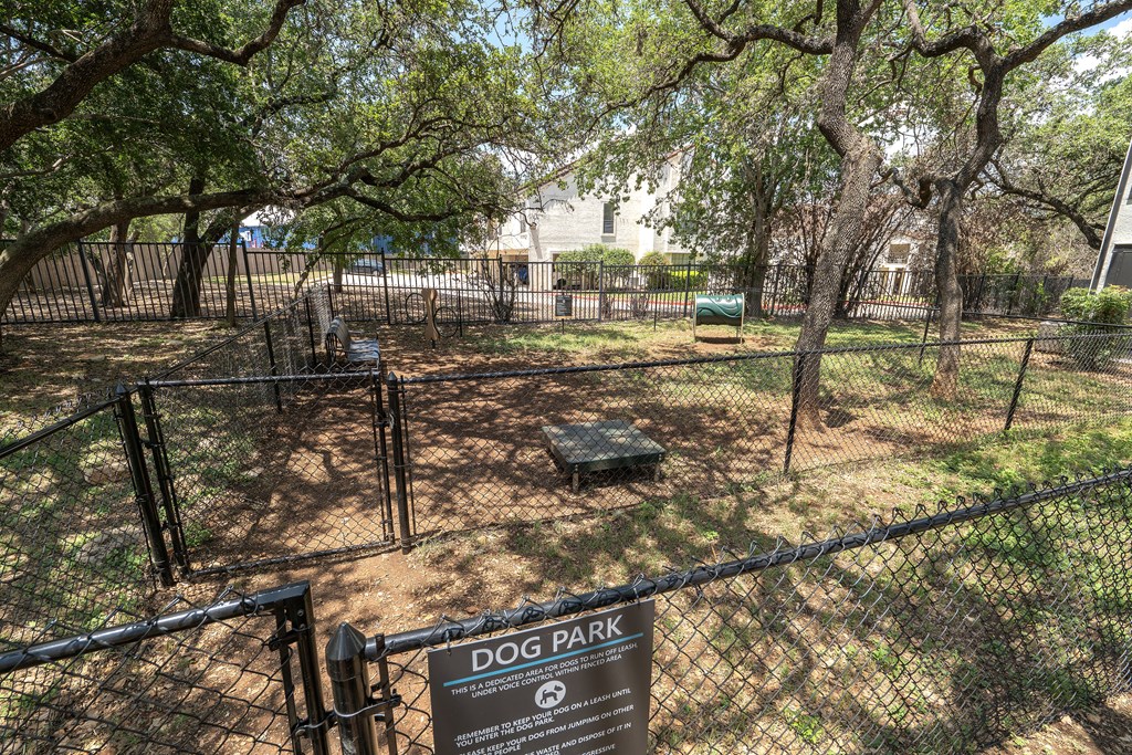 A dog park sign is displayed on a fence.