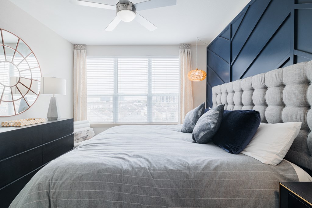 a bedroom with a large bed with pillows and a black and white accent wall