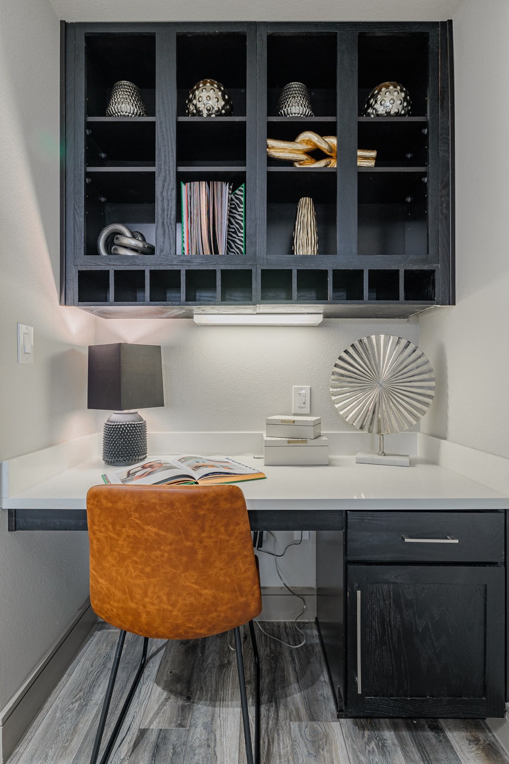 a small desk with a chair and a black cabinet