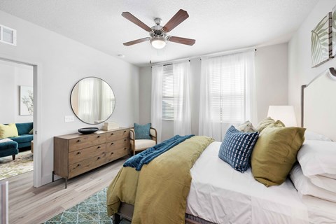A bedroom with a white bed and a blue chair.