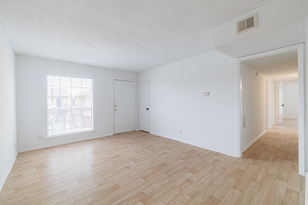 the living room and dining room of an apartment with wood flooring