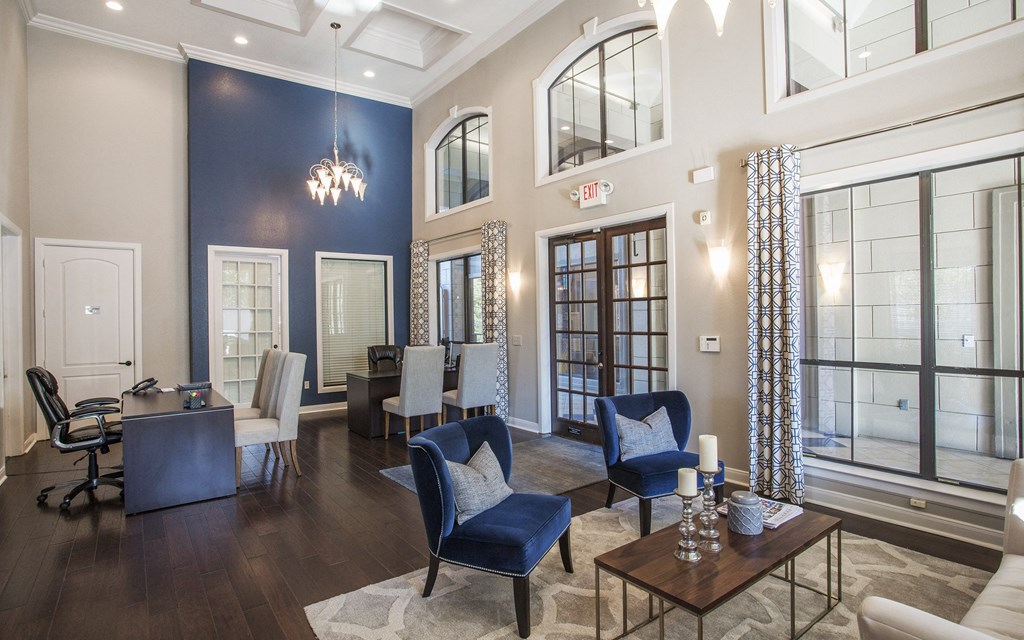 A large room with a blue accent wall and a chandelier.