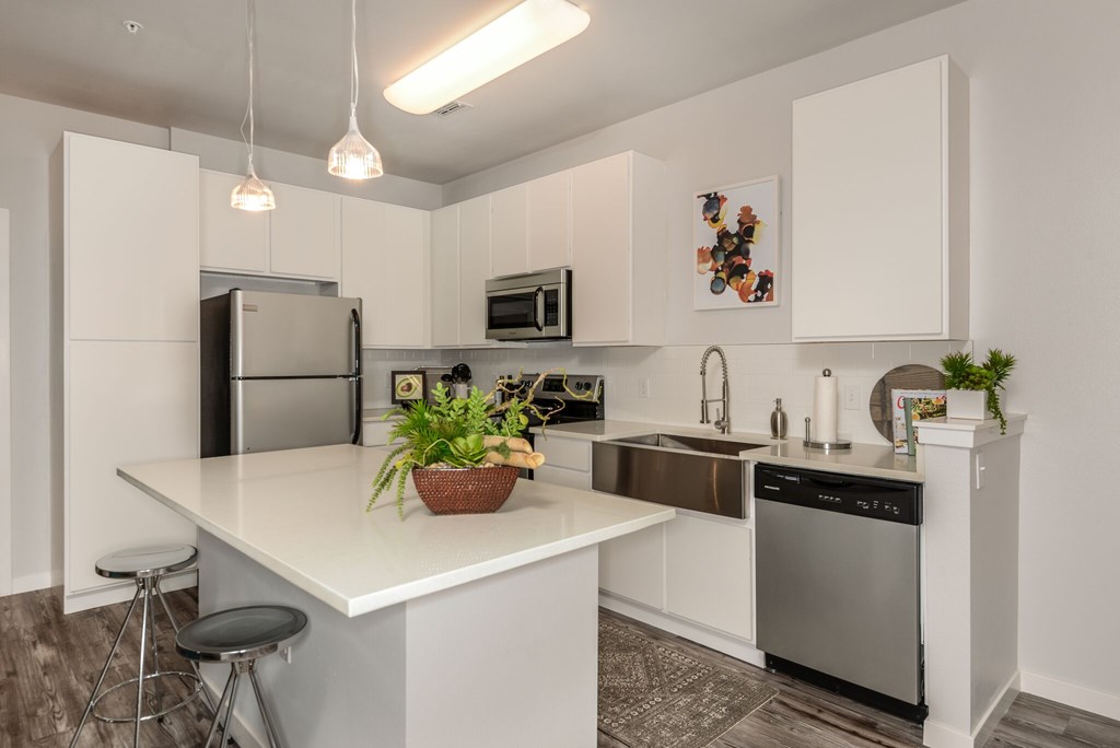 A modern kitchen with white cabinets and stainless steel appliances.