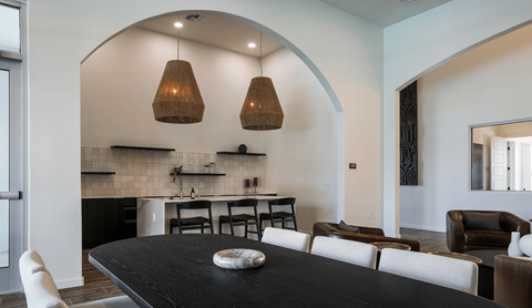 A modern dining room with a black table and chairs.