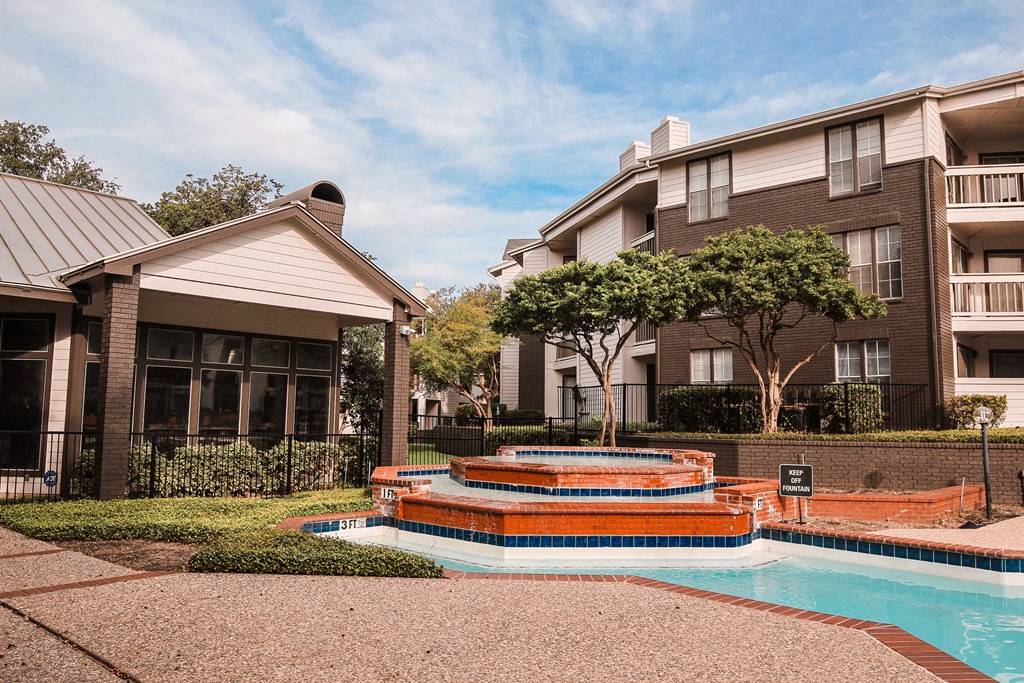 a fountain sits in front of an apartment building