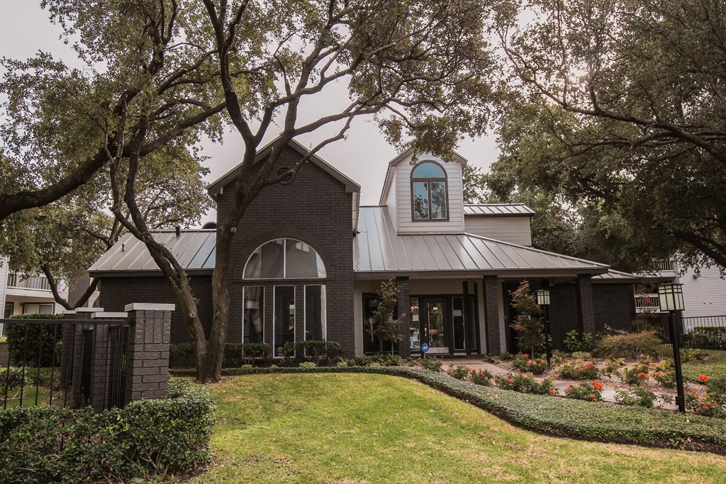 the front of a house with trees and a lawn