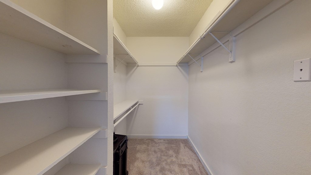 an empty closet with shelves and a light on the ceiling