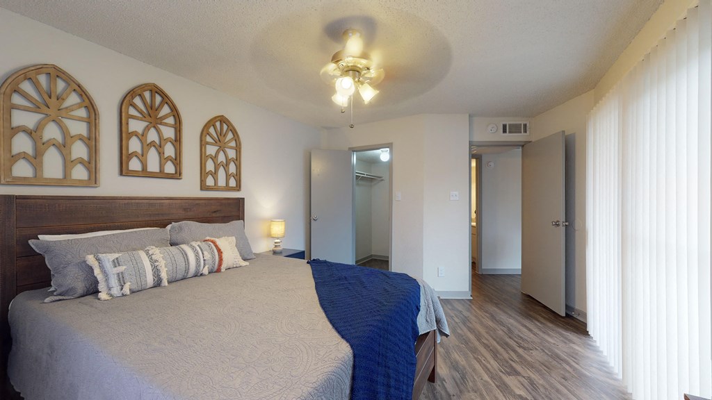 a bedroom with a large bed and a ceiling fan