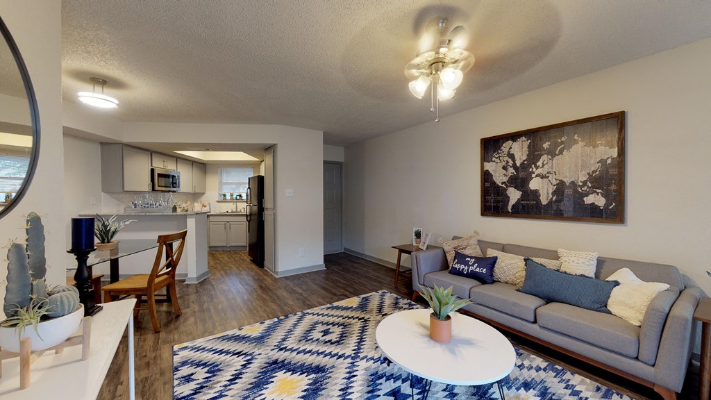 an open living room and kitchen with a couch and a coffee table
