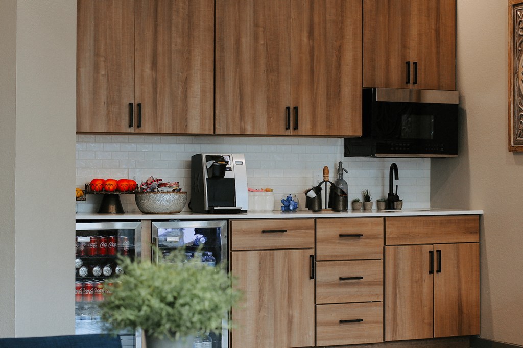 a kitchen with wooden cabinets and a black microwave