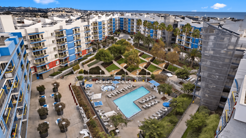 A view of a pool and apartment complex from above.