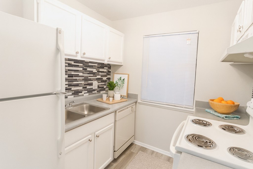 A kitchen with white appliances and cabinets.