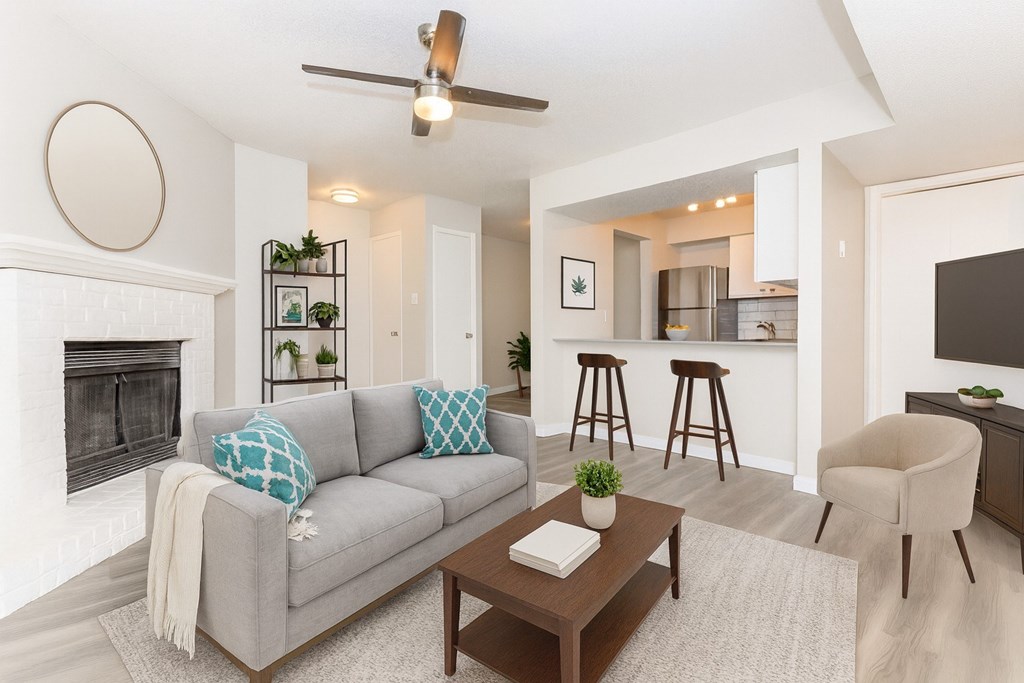 A living room with a grey couch, a coffee table, and a fireplace.