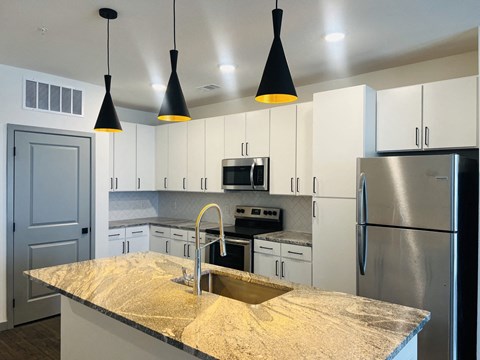a kitchen with white cabinets and a granite counter top