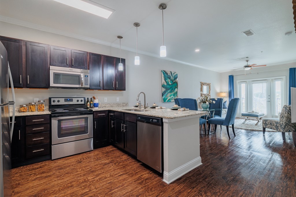 an open kitchen and living room with a large island and stainless steel appliances