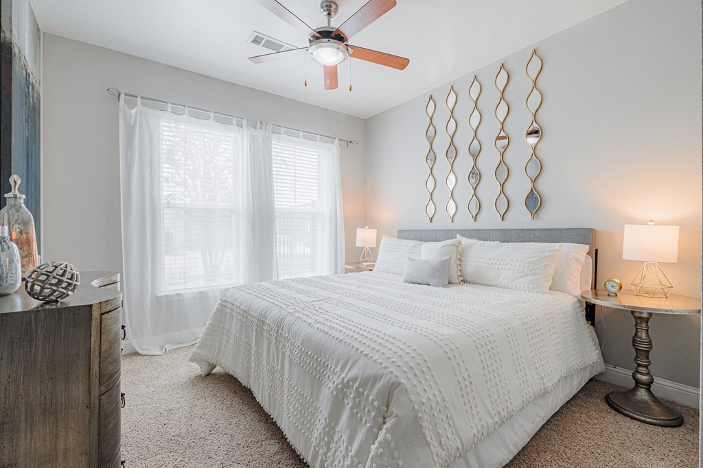 a bedroom with a large bed and a ceiling fan
