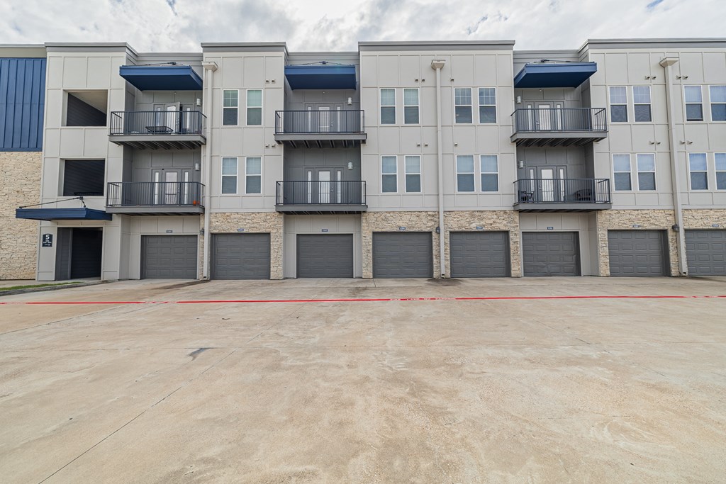 an empty parking lot in front of an apartment building