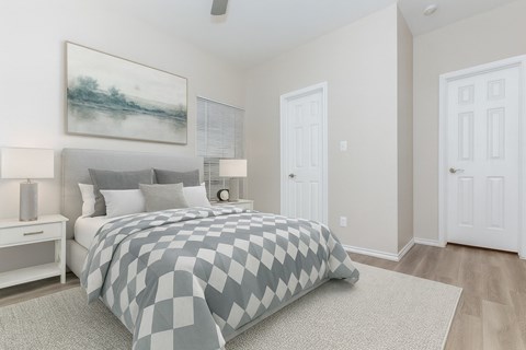 A bedroom with a large bed and a painting on the wall.