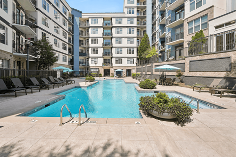 A large swimming pool in the middle of a courtyard surrounded by buildings.