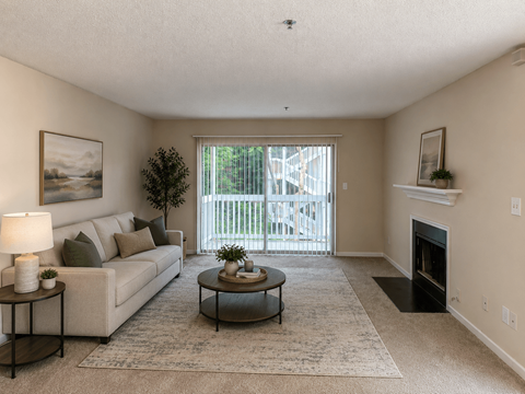 A living room with a couch, coffee table, and fireplace.
