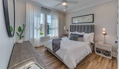 A bedroom with a large bed and a ceiling fan.