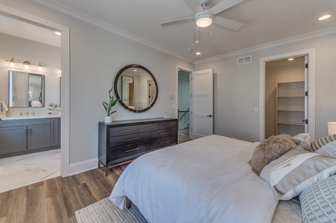 A bedroom with a large bed and a mirror on the wall.