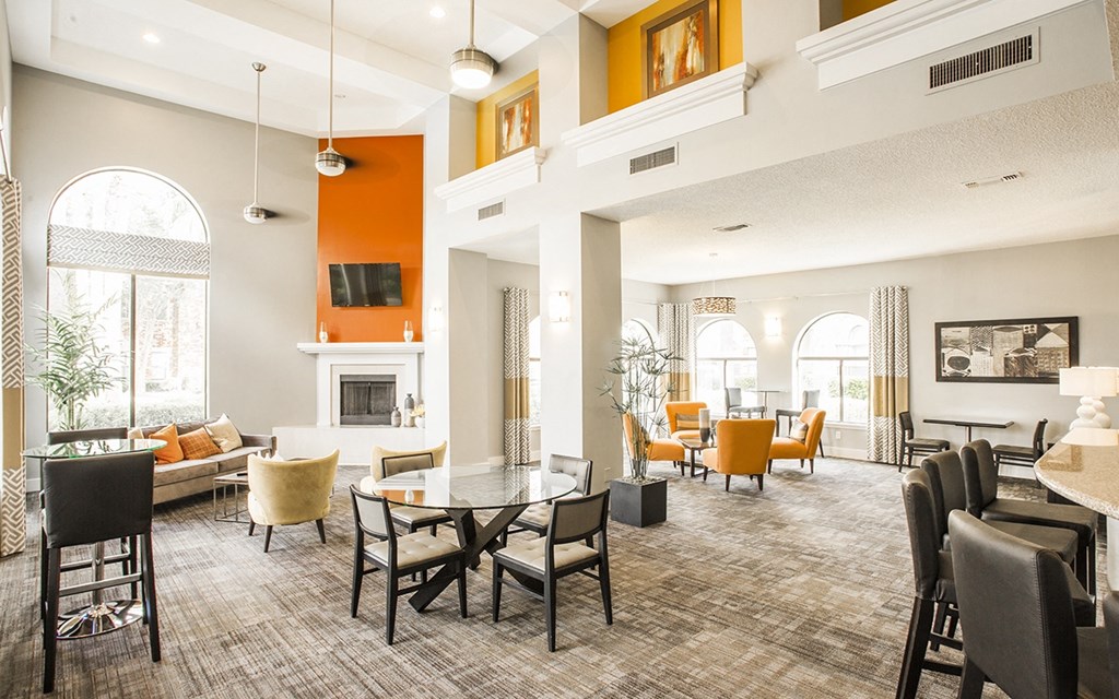 a large living room with tables and chairs and a fireplace