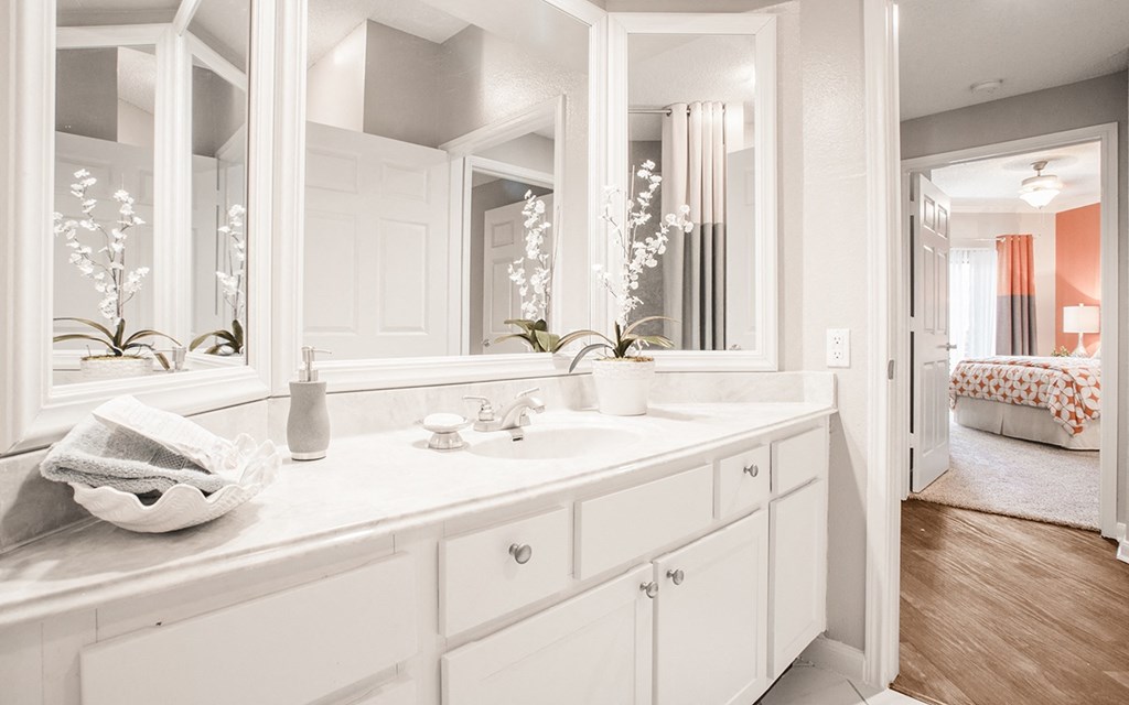 a white bathroom with a large mirror and a sink