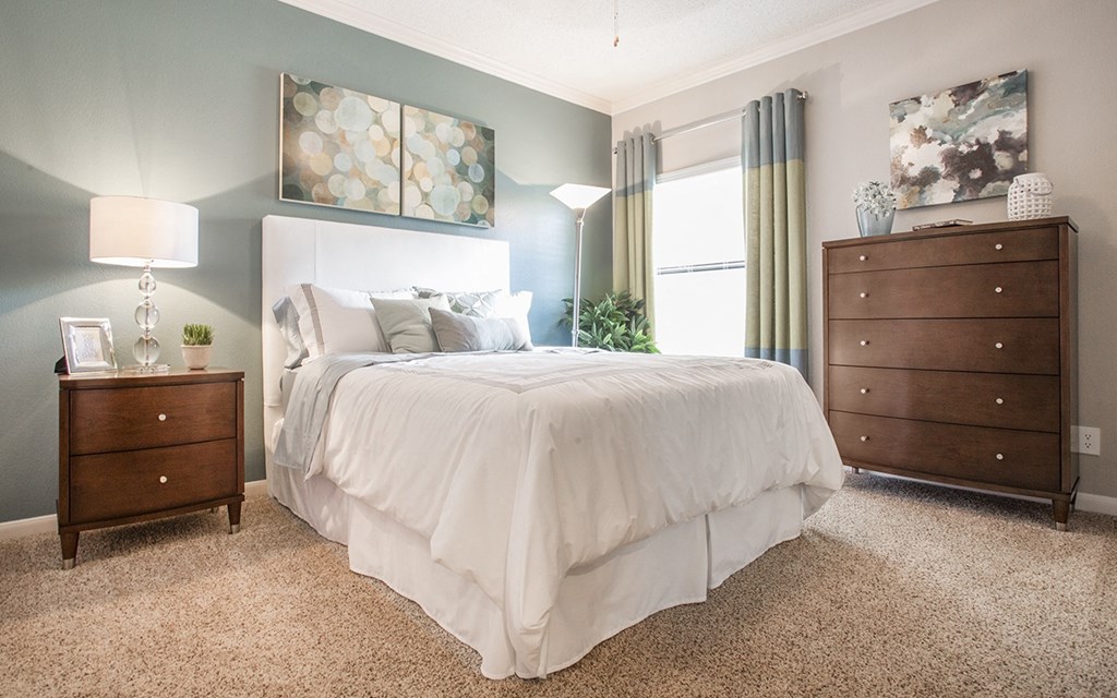 a bedroom with a bed and two dressers