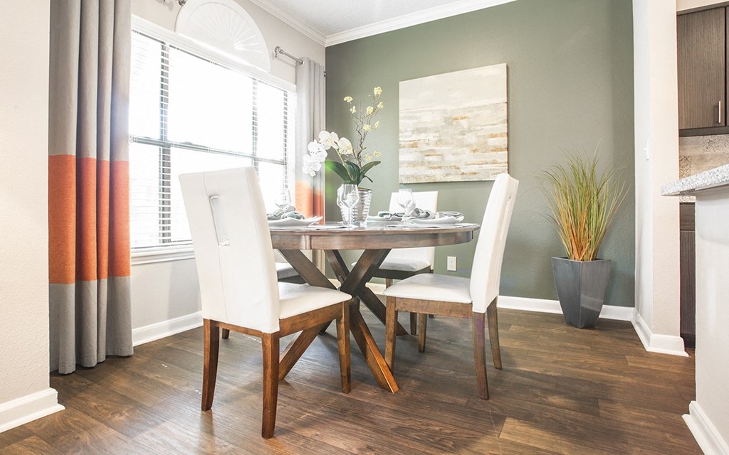 a dining room with a table and chairs and a window
