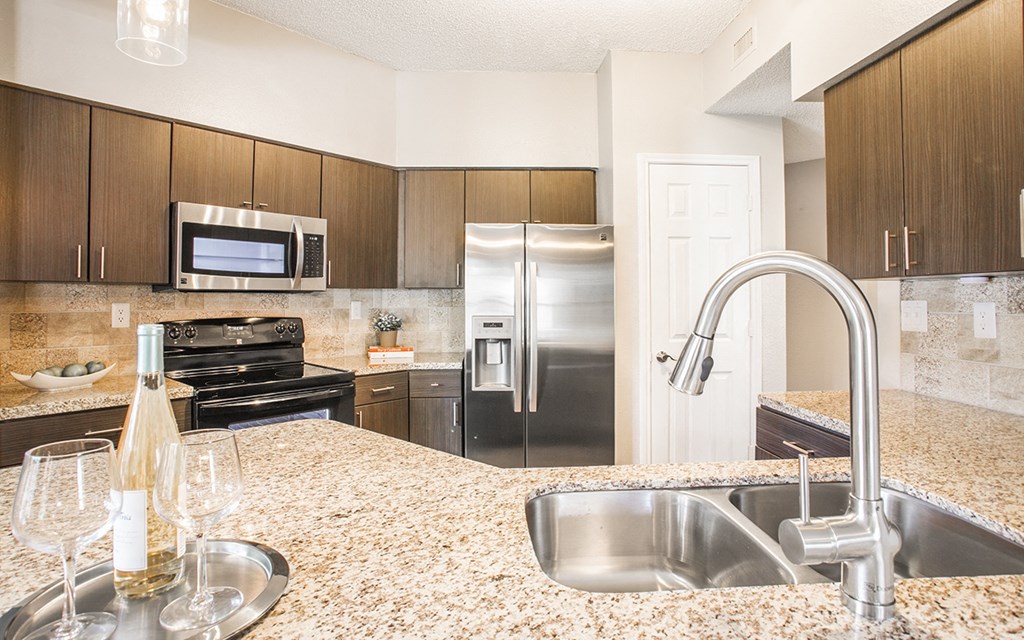 a modern kitchen with stainless steel appliances and marble counter tops