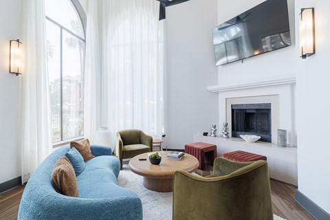 A living room with a blue couch and a fireplace.