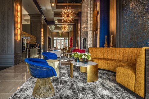 the lobby of a hotel with yellow couches and blue chairs