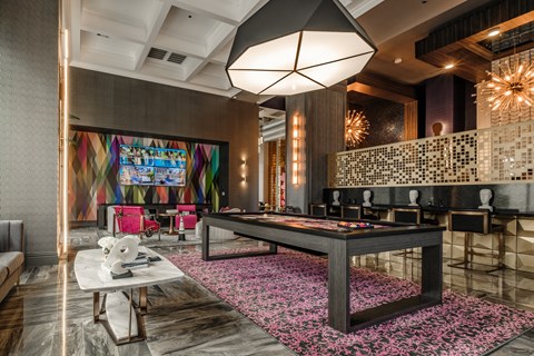 a game room with a pool table and a colorful painting on the wall