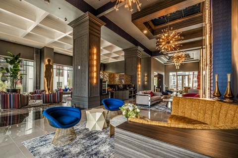 a lobby of a hotel with blue chairs and couches