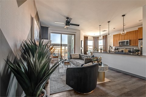 A modern living room with a large black armchair and a wooden floor.