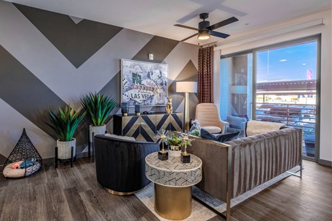 A living room with a grey sofa and a black and white patterned rug.