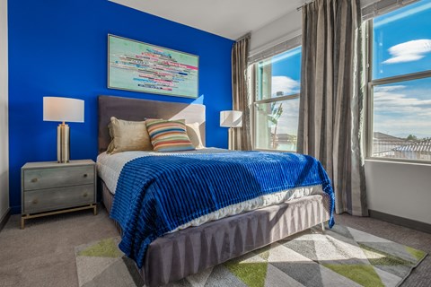 a bedroom with a bed and two windows